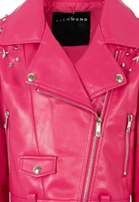 Giacca da motociclista in pelle rosa con hardware in argento, borchie, cerniere asimmetriche e una tasca a pattina. Il colletto è ampio con rever.