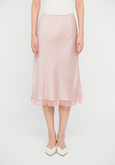 En lyserød satin midi-nederdel med en fløjlsagtig, lagdelt kant, der har en elastisk talje og en glat tekstur. Båret med slid-til-sko.