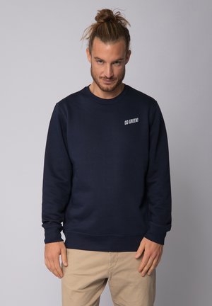 Navy blue sweatshirt made of cotton blend, featuring a round neckline and ribbed cuffs. Printed "GO GREEN!" logo on the left chest.