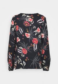 Blouse fleurie en tissu noir ornée de fleurs rouges et roses avec des feuilles vertes. Manches longues avec poignets élastiques et col rond.