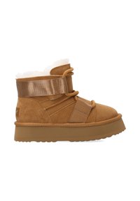 Bruine suède enkelboot met een zachte fleece voering, voorzien van een brede satijnen band en een dikke rubberen zool voor grip. Rond neusontwerp.