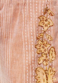 Brzoskwiniowa tkanina z pionowymi paskami, zdobiona misternym złotym haftem kwiatowym z akcentami z koralików po jednej stronie. Miękka w dotyku i lekka.