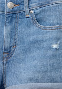 Ljusblå denimshorts med synlig sömnad, knäppning och en sliten patch vid framfickan.