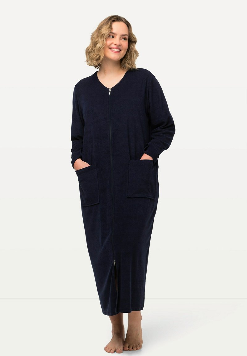 Námořnický modrý dlouhý župan z měkké tkaniny, s předním zipem, dvěma velkými kapsami a dlouhými rukávy. Délka do poloviny lýtek, rovný střih.