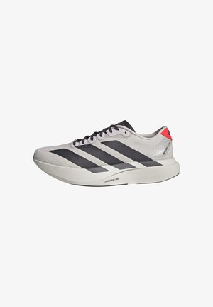 Witte hardloopschoen met zwarte strepen, zwarte veters, rode hielstrip en dikke Lightstrike Pro-zool op een witte achtergrond.