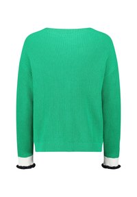 Zelený žebrovaný svetr s dlouhými rukávy, s bílými a černými volánkovými manžetami, zobrazený zezadu na bílém pozadí.