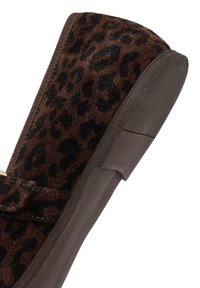 Scarpa slip-on in stampa leopardo, parte superiore in camoscio marrone con macchie nere, texture morbida e suola in gomma resistente. Presenta un design semplice e tacco piatto.