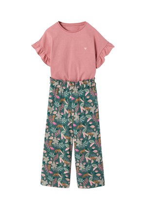 Pink short-sleeve top with ruffled sleeves and a small heart detail paired with green wide-leg pants featuring a multicolored floral and animal print.