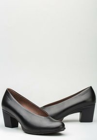 Zapatos de tacón alto de cuero negro con puntera redondeada y escote bajo. Diseño de tacón bloque y textura suave con mínima marca.
