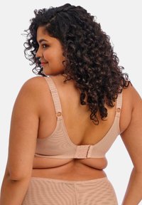 Beige rintaliivi, jossa on säädettävät hihnat ja hakaset. Pehmeä, teksturoitu kangas, jossa on hienovarainen kuvio. Täyspeittävä muotoilu, joka sisältää sileän selän.