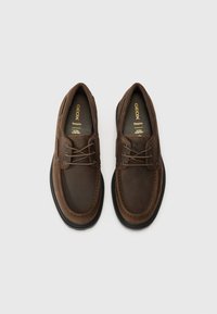 Brown leather shoes with a rounded toe, lace-up design, and stitching details. Black rubber soles provide traction and support.