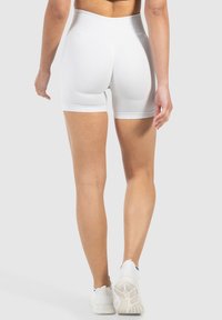 Pantalones cortos atléticos blancos de cintura alta con una textura suave, diseño ajustado y un acabado limpio en el dobladillo. Sin patrones o acentos visibles.