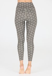 Hoge taille leggings in beige met een zwart bloemenpatroon. Gemaakt van rekbare stof, met een zachte textuur en een aansluitend ontwerp.