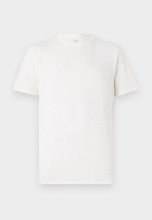 T-shirt à manches courtes, col rond, de couleur blanc cassé, fabriqué en un mélange de coton doux avec une finition légèrement texturée et sans motifs ni accents visibles.