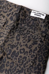 Kangaskuvio, jossa on mustia leopardi täpliä khaki-taustalla. Sisältää kaksi taskua ja lapun, jossa lukee "COLOURFUL REBEL."