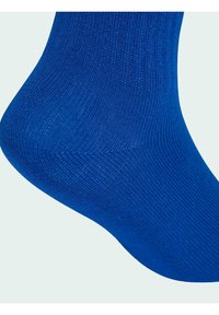 Niebieska skarpeta wykonana z prążkowanej dzianiny, charakteryzująca się gładką fakturą i dopasowanym krojem. Widoczny szew w okolicy palców.