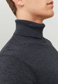 Pull à col roulé gris foncé, encolure côtelée, design ajusté, texture douce, coutures minimalistes et finition lisse.