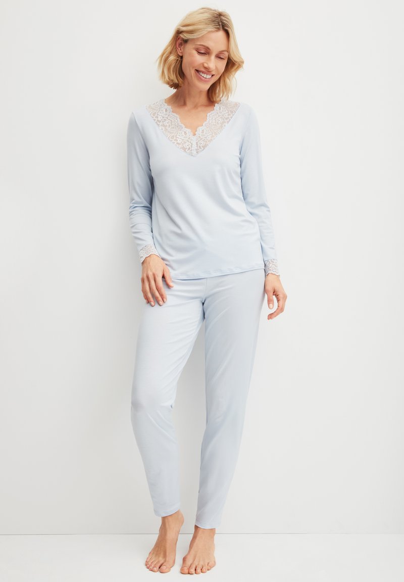 Lichtblauw pyjama set met een V-halslijn met kantafwerking en lange mouwen, aansluitende broek ontworpen voor comfort en bewegingsgemak.