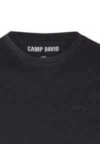Sort t-shirt med rund hals, der har et tekstureret "CAMP DAVID" logo i en matchende nuance på brystet og kraven. Glat stof.