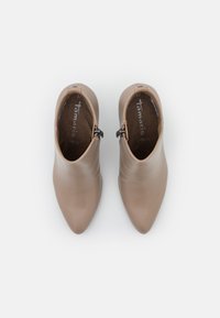 Stivali alla caviglia color taupe in pelle liscia, con punta affusolata e dettagli in zip argentata. Misura 37 interna.