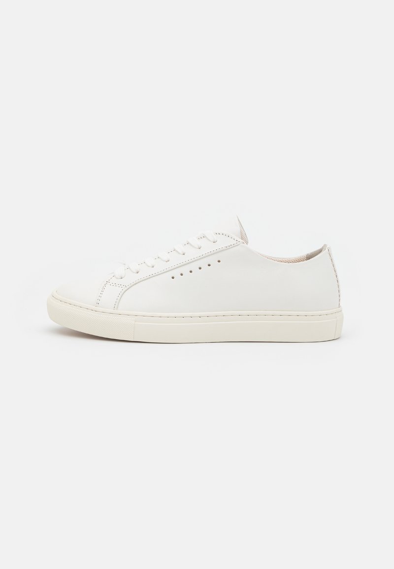 White leather sneakers with a smooth texture, round toe, minimal eyelets, and a flat rubber sole. Simple design with no additional accents.
