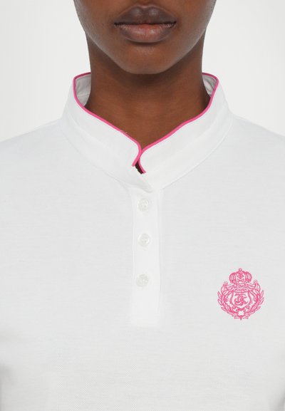 Hvit polo-skjorte med en unik kragedesign og rosa kanting, fire knapplukking og et rosa broderi-emblem på venstre bryst.
