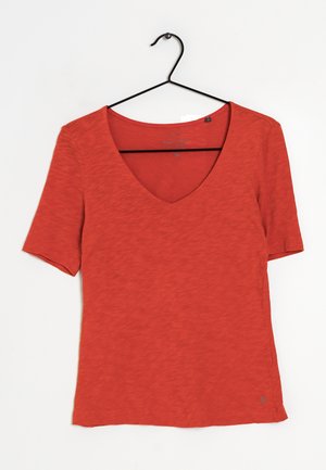 Rød T-shirt med korte ærmer og V-hals, lavet af blødt tekstureret stof, med en lille logo ved kanten og et afslappet design.