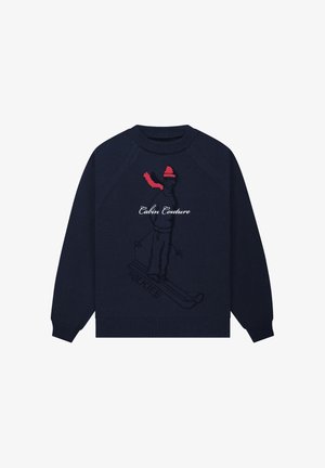 Granatowy dzianinowy sweter z żebrowanym kołnierzem typu crew neck, z grafiką narciarza w kolorach czarnym i czerwonym oraz napisem „Cabin Couture” w białym kolorze.