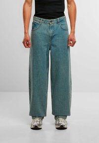 Lyseblå vide jeans med en falmet tekstur, som har et klassisk fem-lomme design, knaplukning og subtile stikninger.