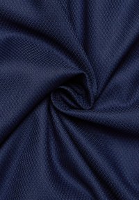 Tessuto blu navy con trama geometrica a piccoli rombi, superficie liscia, caduta morbida, adatto per abbigliamento o tappezzeria.