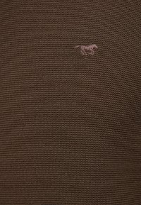 Tissu tricoté marron avec un subtil logo de cheval brodé dans une teinte plus claire. La texture est côtelée et suit un motif régulier.