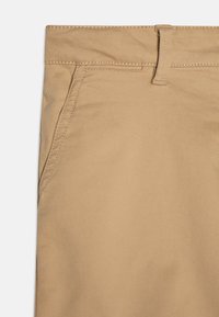 Pantaloni kaki con tessuto a twill, caratterizzati da una superficie liscia, passanti per cintura e una tasca laterale. Design semplice con cuciture rinforzate.
