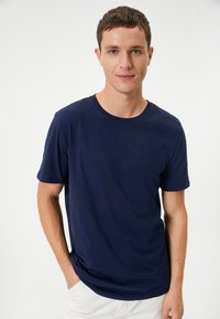 Mörkblå bomullströja med korta ärmar, rund hals och avslappnad passform, med en slät yta och inga synliga mönster eller detaljer.