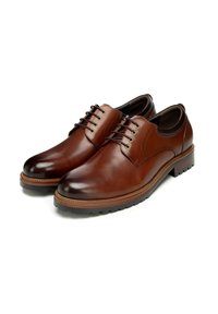 Brązowe skórzane buty wizytowe o błyszczącym wykończeniu, zaokrąglonym nosku i ozdobnym sznurowaniu. Charakteryzują się kontrastową podeszwą i subtelnym przeszyciem.