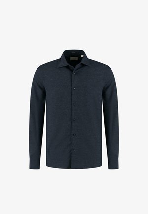 Temno modra srajca z dolgimi rokavi, izdelana iz teksturiranega materiala. Ima klasičen ovratnik, sprednje gumbke in žep na levi strani.