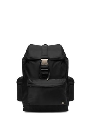 Zaino nero con patta superiore, tasca frontale con cerniera, tasche laterali e chiusura centrale con fibbia metallica. Design compatto e funzionale.