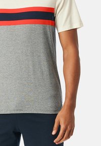 Korte mouw T-shirt in crème, grijs en marineblauw met rode horizontale strepen. Gemaakt van een zachte katoenmix. Heeft een ronde hals en een relaxte pasvorm.