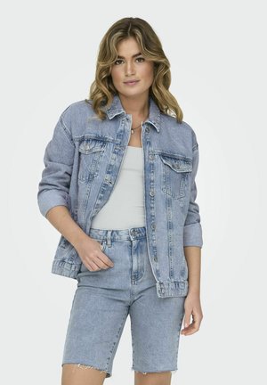 Veste en denim bleu clair avec une coupe décontractée, deux poches poitrine et des manches retroussées, associée à un short en denim assorti. Texture douce.