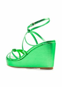 Sandalias de cuña verdes con un acabado metálico brillante y múltiples correas cruzadas, aseguradas con una correa ajustable en el tobillo.