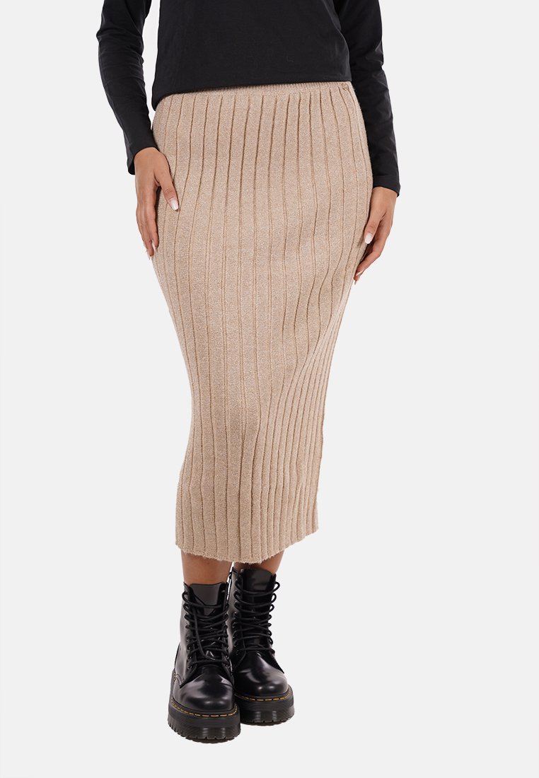 Gonna midi beige in maglia con texture a coste verticali, abbinata a stivali combat neri con lacci. La gonna presenta una silhouette aderente e una cintura elastica.
