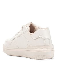 Baskets basses blanches avec semelle texturée, col rembourré, laçage à l'avant et détails cousus sur le côté et le talon.