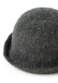 Sombrero de fieltro gris con una corona redondeada y una superficie de textura suave. Presenta un ala ancha que se curva hacia abajo.