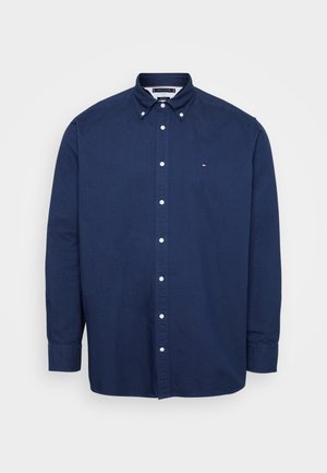 Navy blue button-up shirt made of cotton. Features a button-down collar, long sleeves, and a small logo on the chest.