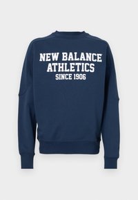 Navy blue sweatpaita puuvillasekoitteesta, jossa on pitkät hihat, ribbaus hihansuissa ja kaula-aukossa. Sisältää valkoista tekstiä: "NEW BALANCE ATHLETICS SINCE 1906."