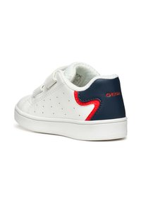 Sneaker bianca con design perforato, dettagli in rosso e blu scuro, strap in Velcro e fodera morbida. Marchio Geox sul tallone, suola in gomma.