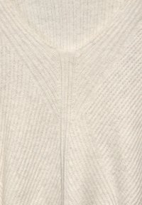 V-Ausschnitt-Pullover aus weichem, cremefarbigen Stoff mit einer strukturierten, gerippten Optik und diagonalen Nähten entlang der Nähte.