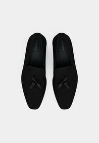 Pantofi negri tip slip-on cu un superior din material fin, design cu vârf ascuțit și cravate decorative negre în față. Interioare texturate negre.