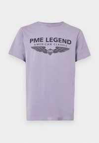 Levandulové bavlněné tričko s černým grafickým designem, obsahující nápisy "PME LEGEND" a "AMERICAN CLASSIC", spolu s motivy křídel.