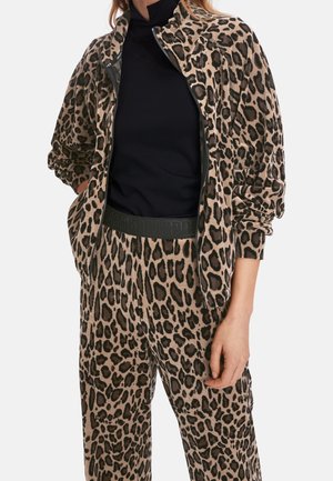 Dres w panterkę w odcieniu brązowym i czarnym. Miękki materiał, kurtka zapinana na zamek z bocznymi kieszeniami, pasujące spodnie z elastycznym pasem i detalem logo.