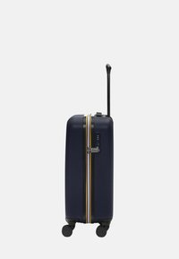 Harde navy koffer met gele en witte strepen, uitschuifbare handgreep, wielen om te rollen en een combinatie slot aan de zijkant.